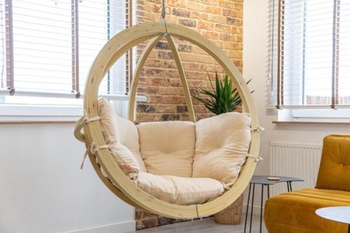 a swing chair in a living room with a couch at Apartament Centrum III in Bydgoszcz