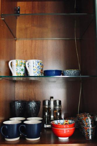 a shelf with bowls and cups on it at Kiko's Lodge - Historical Apartment in Como in Como