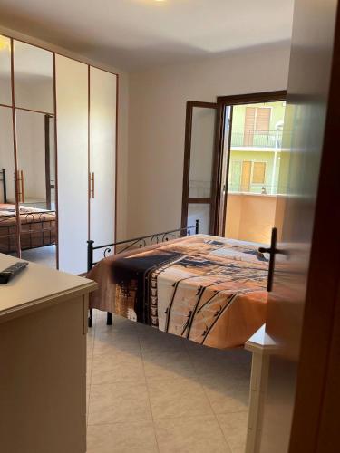 een slaapkamer met een bed en een groot raam bij Appartamento Ladispoli in Ladispoli