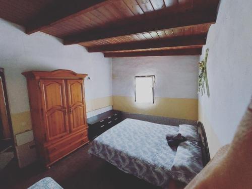 a bedroom with a bed and a wooden cabinet at Casa Rural Tindaya in Tindaya