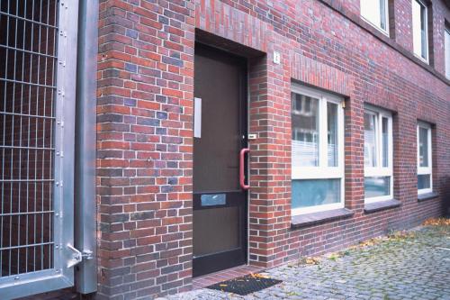 a brick building with a black door and windows at schönes Apartment in der Altstadt , kostenlose Parkplätze in der Nähe in Emden