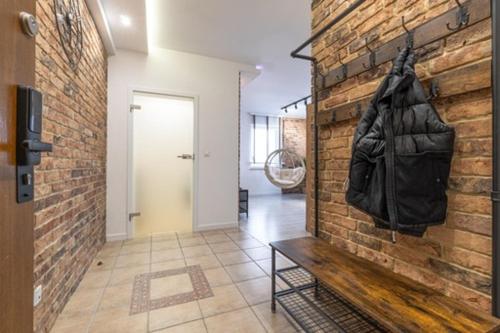 een hal met een stenen muur met een handtas erop bij Apartament Centrum III in Bydgoszcz