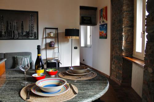 a table with plates and a bottle of wine on it at Kiko's Lodge - Historical Apartment in Como in Como