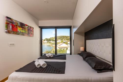 a bedroom with a large bed with a large window at Villa Veronica mit Pool und Bootsliegeplatz direkt am Meer in Palit