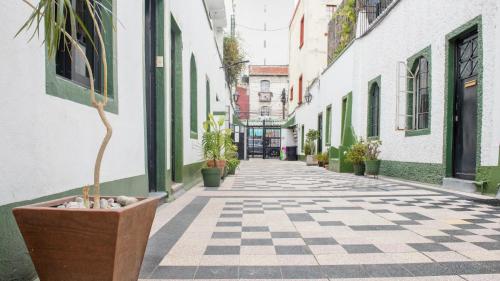 an empty alley with potted plants and buildings at Charming House at Roma in Mexico City
