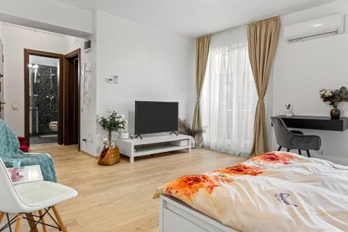 a bedroom with a bed and a flat screen tv at La vie est belle in Bucharest