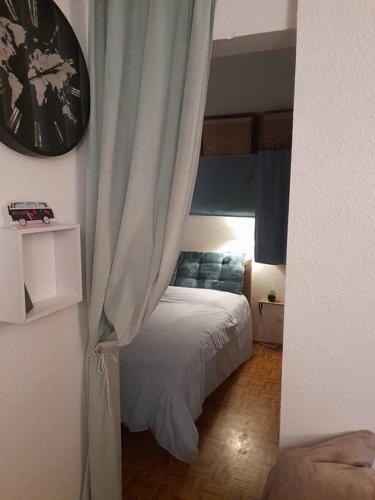 une chambre avec un lit et une horloge au mur dans l'établissement Rez de jardin / pieds des pistes, à Bernex