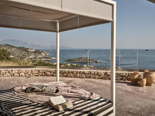 a bed in a room with a view of the ocean at Meraki in Agios Nikolaos