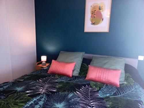 1 cama con 2 almohadas rosas en una habitación en Le Barcares bel appartement 62m2 -2 chambres en Le Barcarès