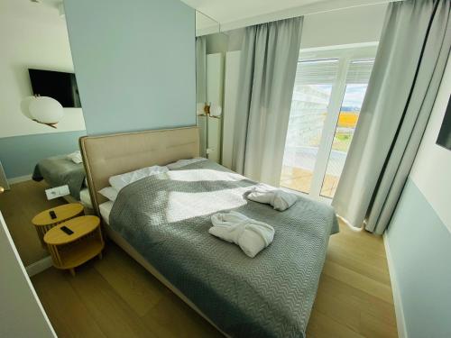 1 dormitorio con 1 cama con toallas en Polanki Aqua Apartament FLORA en Kołobrzeg