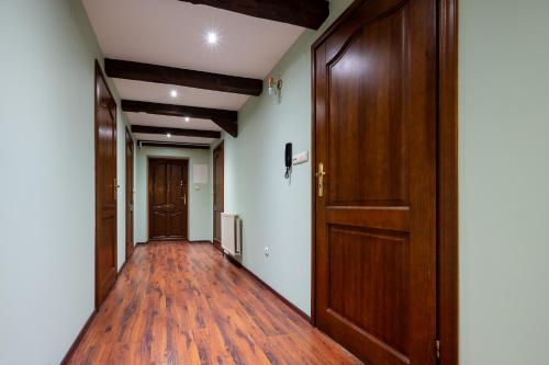 an empty hallway with wooden doors and wooden floors at Pokoje przy Dworcu in Przemyśl