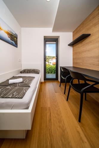 a bedroom with a bed and a dining table at Villa Veronica with pool first line at sea in Palit