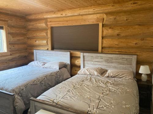 韋爾芒特的住宿－Cougar Mountain Cabin Rentals，小木屋内一间卧室,配有两张床