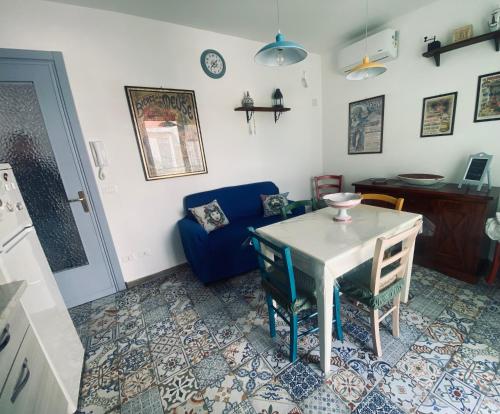- un salon avec une table et un canapé bleu dans l'établissement kasakora, à Casteldaccia