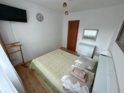 a small bedroom with a bed and a clock on the wall at Magnolia Truskavets in Truskavets