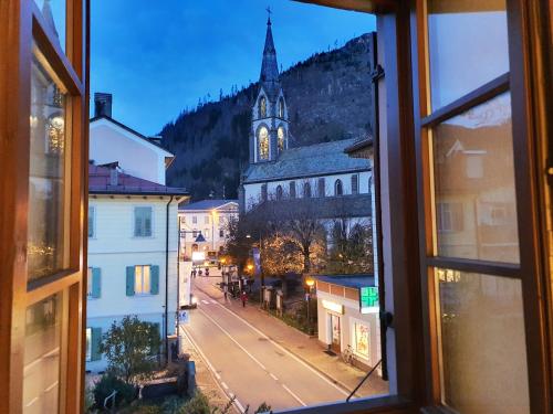 a view from a window of a town with a church at ElvesHome - Alpine Stay Apartments in Predazzo