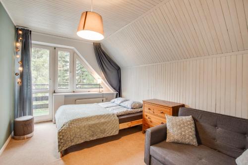 een slaapkamer met een bed, een stoel en een raam bij Willa Bliski in Szczyrk