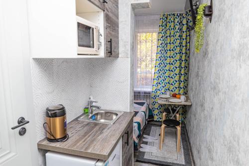 a small kitchen with a sink and a counter at YourHouse на Си Синхая 22 близко к Меге in Almaty