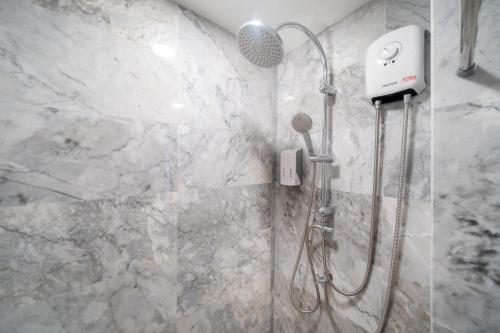 a shower with a shower head in a bathroom at Mountain View Mai Khao Beach Condotel in Ban Bo Sai Klang