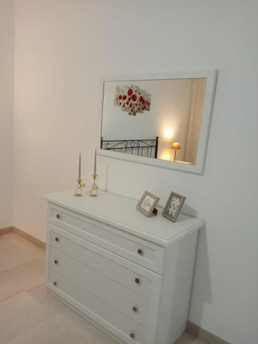- une commode blanche avec un miroir au-dessus dans l'établissement Casa Vacanza Luna2, à Palagiano