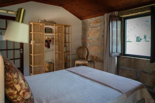 1 dormitorio con cama y ventana en Quinta de Passinhos, en Penafiel