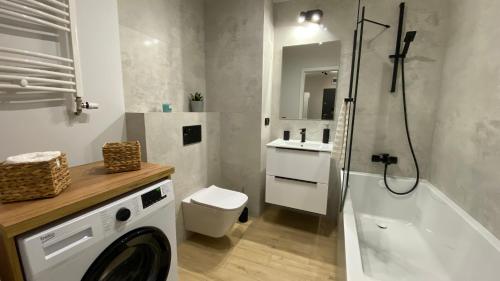 a bathroom with a shower and a toilet and a sink at Apartament GREEN CROWNS in Płock