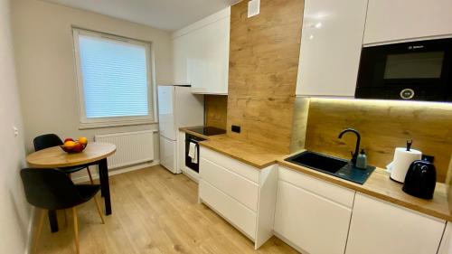 a kitchen with a table and a counter top at Apartament GREEN CROWNS in Płock