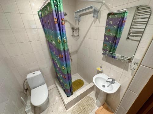 a bathroom with a toilet and a sink and a shower curtain at Magnolia Truskavets in Truskavets