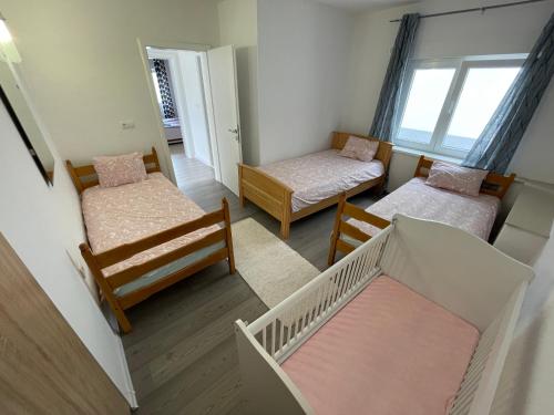Habitación pequeña con 2 camas y cuna en Sunny Apartment with swimming pool Stolac en Stolac