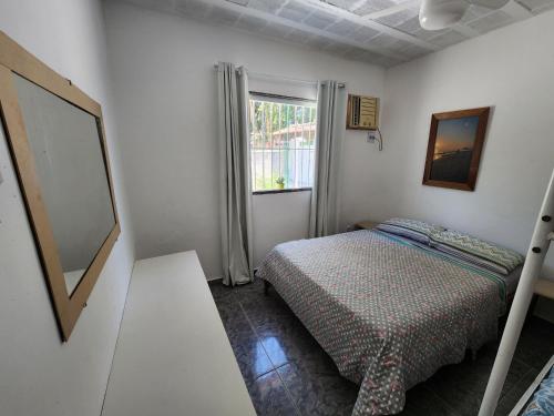 a small bedroom with a bed and a window at Casa Verão de Itaúna in Saquarema