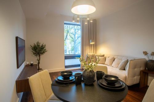 ein Wohnzimmer mit einem Tisch und einem Sofa in der Unterkunft Tatari 16 City Centre New Apartment in Tallinn