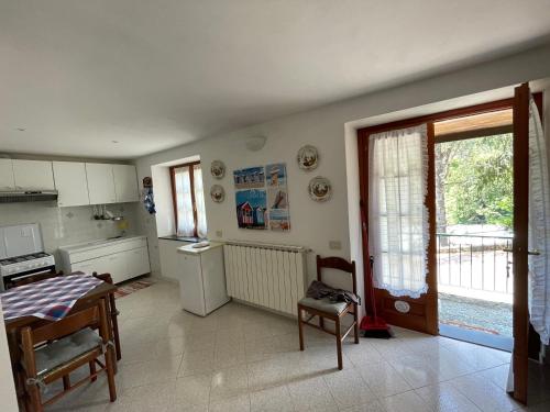 eine Küche mit einem Tisch, einem Kühlschrank und einem Fenster in der Unterkunft L'ulivo in Levanto