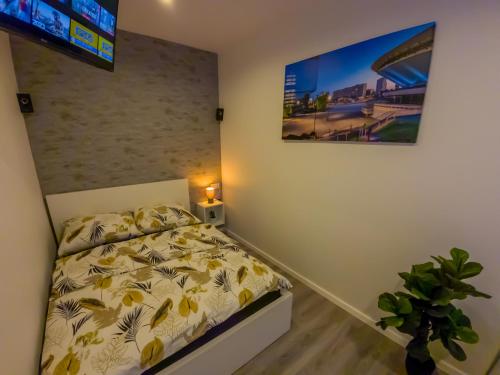 a bedroom with a bed and a tv on the wall at Punkt - Apartamenty z jacuzzi w centrum Katowic in Katowice