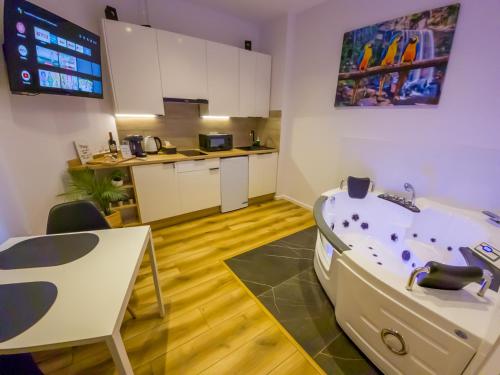 a room with a bath tub and a kitchen at Punkt - Apartamenty z jacuzzi w centrum Katowic in Katowice