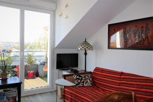 a living room with a couch and a television at Lovely flat close Paris Disney. in Neuilly-sur-Marne