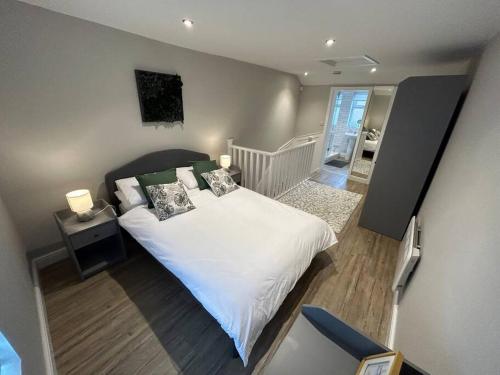 een slaapkamer met een bed met witte lakens en kussens bij Brand New Cosy 1 Bedroom Home in Nantwich