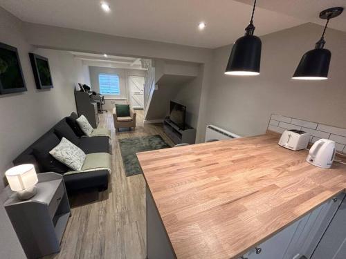 uma cozinha e sala de estar com um balcão de madeira em Brand New Cosy 1 Bedroom Home em Nantwich