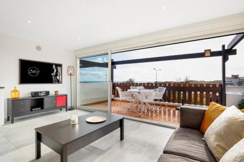 un salon avec un canapé et une grande fenêtre dans l'établissement Village Naturiste R4N - La Villa Aphrodite Sea View, au Cap d'Agde