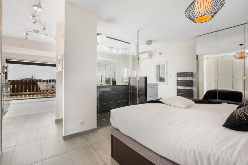une chambre avec un grand lit et une salle de bain dans l'établissement Village Naturiste R4N - La Villa Aphrodite Sea View, au Cap d'Agde