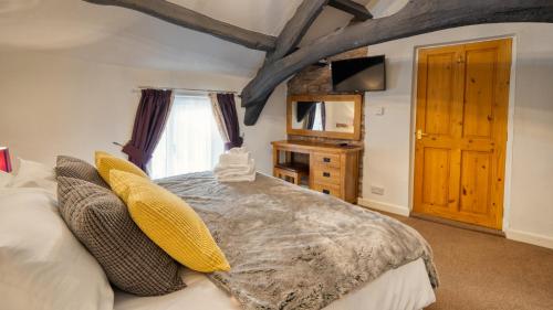 a bedroom with a large bed and a window at Rowrah Hall - The Old Hayloft in Frizington