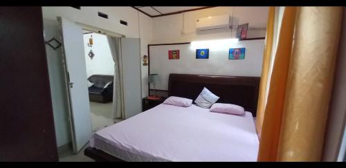 a small bedroom with a white bed with two pillows at RM Holiday Home in Hikkaduwa