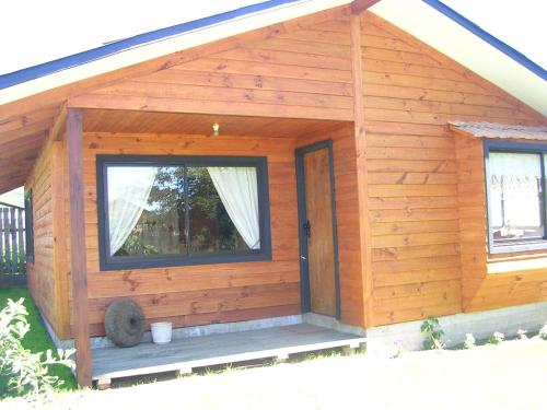 a small wooden cabin with a window and a porch at A&O Courmayeur in Courmayeur