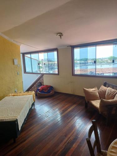 Cette chambre comprend un lit, un canapé et des fenêtres. dans l'établissement Apto vista p canal, à Cabo Frio