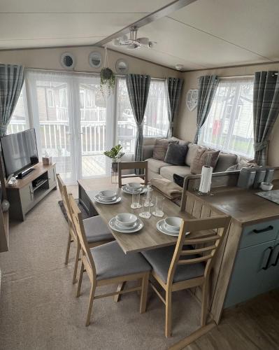 a living room with a table and a couch at 2 Bed Caravan - Sleeps 6 - Parking - Pets in Whitley Bay