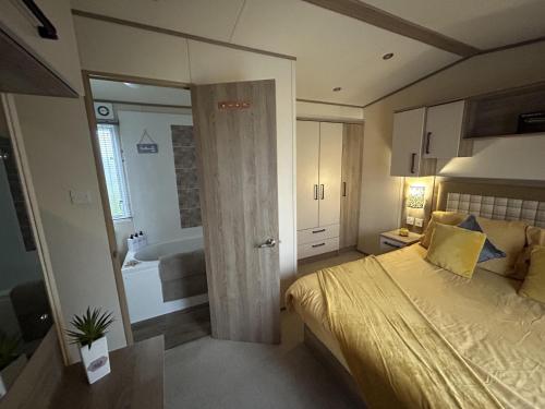 a bedroom with a bed and a bathroom with a tub at Sun sea and sand at Whitley bay caravan park in Whitley Bay