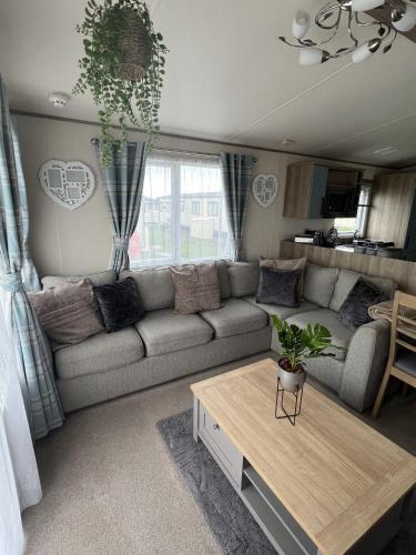 uma sala de estar com um sofá e uma mesa em Sun sea and sand at Whitley bay caravan park em Whitley Bay