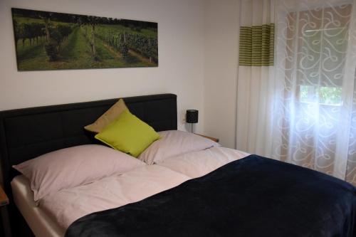 Bett mit gelbem Kissen darüber in der Unterkunft Wein & Wohnen MATZL - Ferienwohnung in Fürstenfeld
