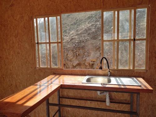 uma cozinha com um lavatório e duas janelas em Ese Lugar Retirado em Miraflores