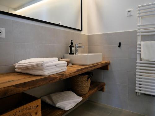a bathroom with a sink and towels on a wooden shelf at La ferme d'Hauteluce - Chambre d'hôtes in Hauteluce