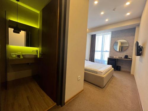 a bedroom with a bed and a sink and a mirror at Hotel Sky Station in Tbilisi City